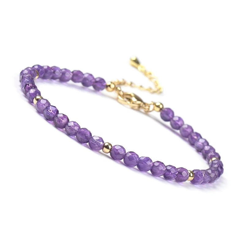 Amethyst beaded bracelet with gold accents on a white background