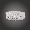 Stack of clear quartz bracelets on a dark gray background