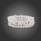Stack of clear quartz bracelets on a dark gray background