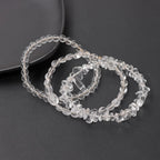 Clear quartz bracelets on a dark surface
