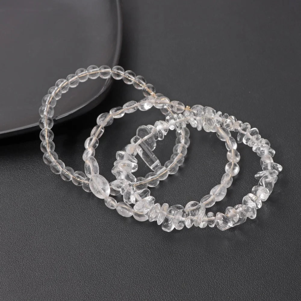 Clear quartz bracelets on a dark surface