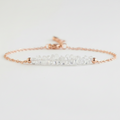 Gold tone bracelet with clear quartz on a light gray background