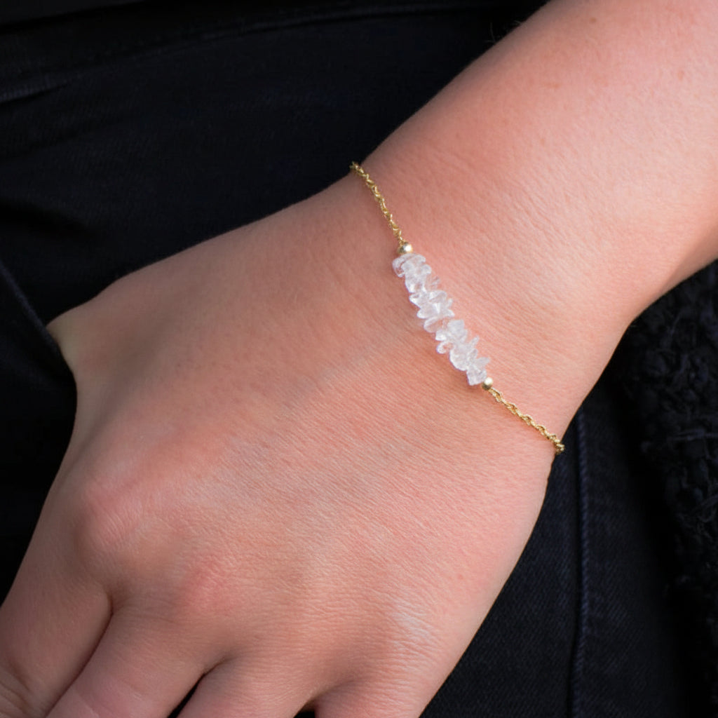 Chain bracelet with clear quartz on a wrist.