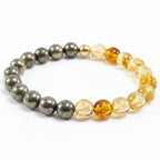 Bracelet with alternating pyrite and yellow crystal citrine beads on a white background