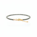 Bracelet with pyrite nugget beads and gold clasp on a white background