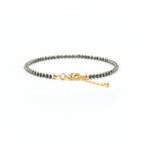 Bracelet with pyrite nugget beads and gold clasp on a white background
