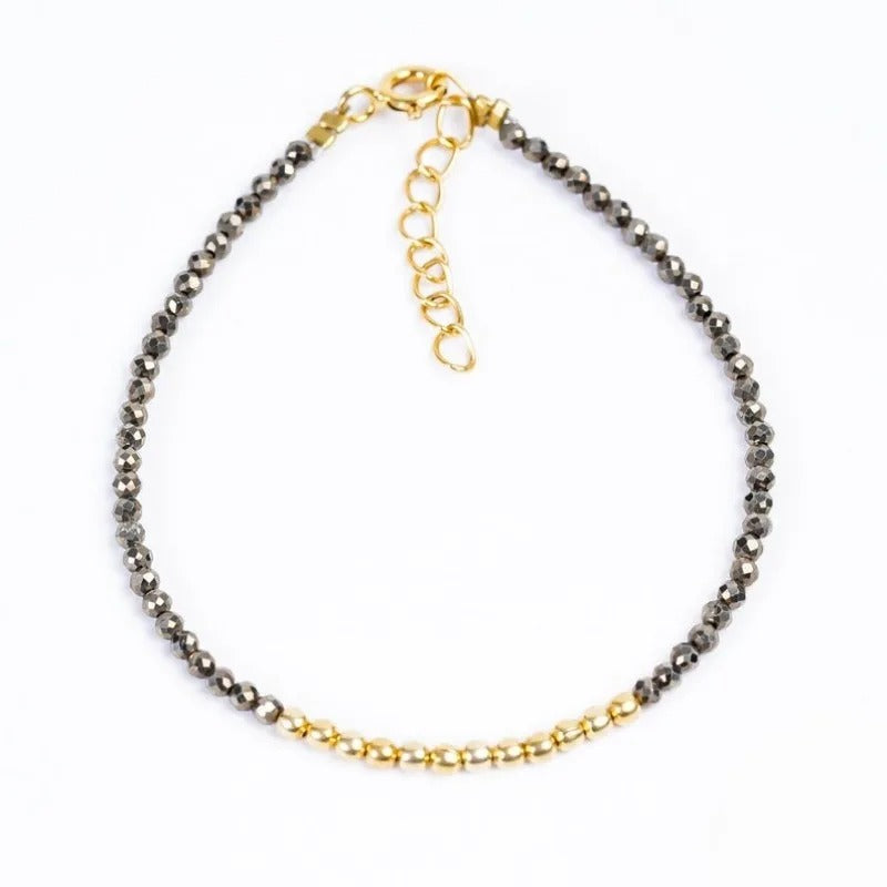 Pyrite nugget bead bracelet with golden metal accents and clasp on white backdrop.